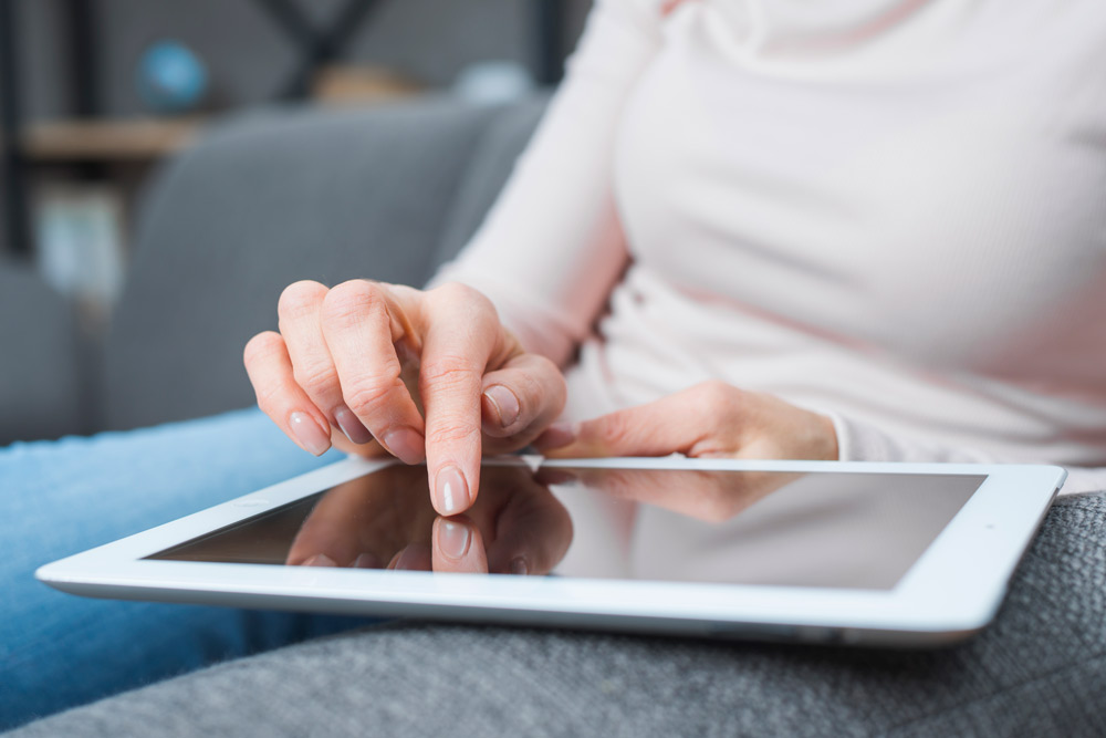 close up woman s hand touching modern digital screen with finger